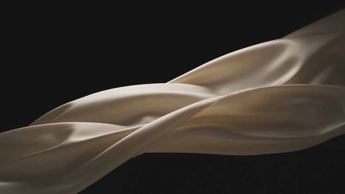 Cream silk drifting slowly through black
